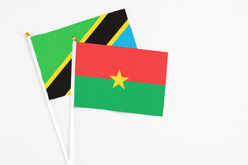 Burkina Faso and Tanzania stick flags on white background. High quality fabric, miniature national flag. Peaceful global concept.White floor for copy space.