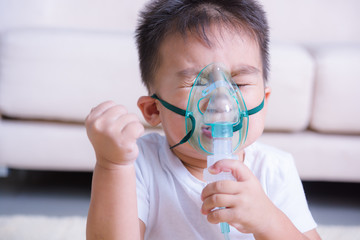 Closeup asian face little children boy using steam inhaler nebulizer mask inhalation