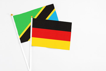 Germany and Tanzania stick flags on white background. High quality fabric, miniature national flag. Peaceful global concept.White floor for copy space.