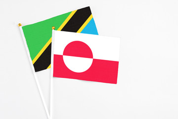 Greenland and Tanzania stick flags on white background. High quality fabric, miniature national flag. Peaceful global concept.White floor for copy space.