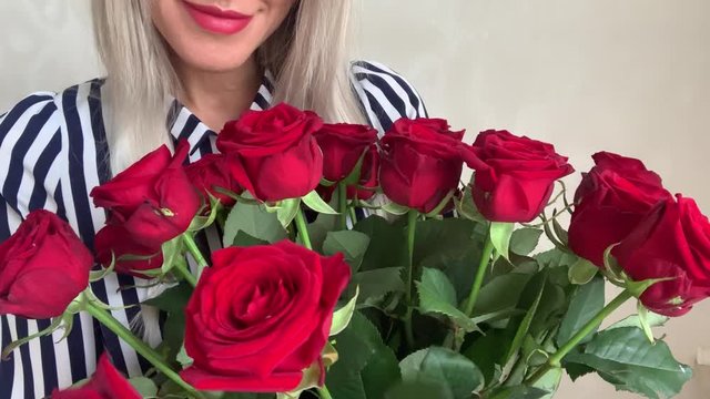 Beautiful woman blonde with a bouquet of red roses