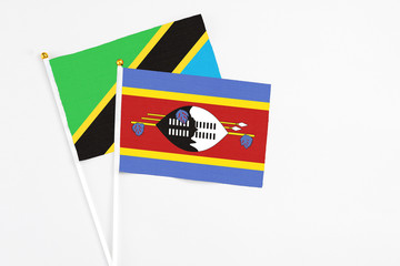 Swaziland and Tanzania stick flags on white background. High quality fabric, miniature national flag. Peaceful global concept.White floor for copy space.