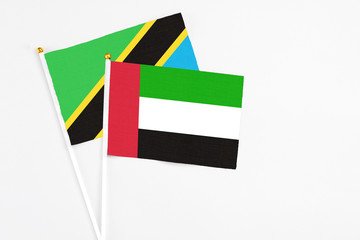 United Arab Emirates and Tanzania stick flags on white background. High quality fabric, miniature national flag. Peaceful global concept.White floor for copy space.
