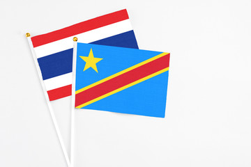 Fototapeta premium Congo and Thailand stick flags on white background. High quality fabric, miniature national flag. Peaceful global concept.White floor for copy space.