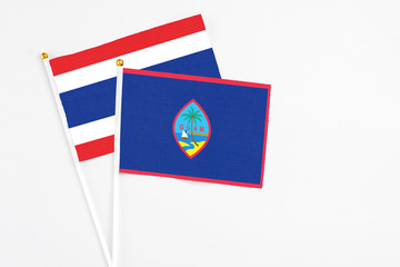 Guam and Thailand stick flags on white background. High quality fabric, miniature national flag. Peaceful global concept.White floor for copy space.