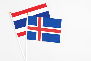 Obraz premium Iceland and Thailand stick flags on white background. High quality fabric, miniature national flag. Peaceful global concept.White floor for copy space.