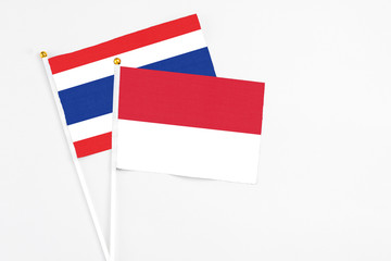 Indonesia and Thailand stick flags on white background. High quality fabric, miniature national flag. Peaceful global concept.White floor for copy space.