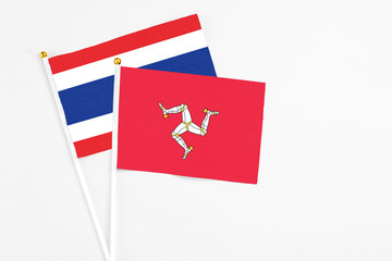 Isle Of Man and Thailand stick flags on white background. High quality fabric, miniature national flag. Peaceful global concept.White floor for copy space.