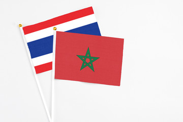 Morocco and Thailand stick flags on white background. High quality fabric, miniature national flag. Peaceful global concept.White floor for copy space.
