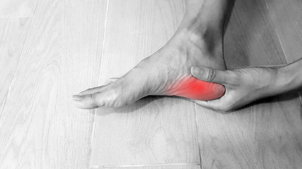 Foot anatomy with red highlight on painful area.  Heel pain may cause from muscle strain,...