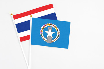 Northern Mariana Islands and Thailand stick flags on white background. High quality fabric, miniature national flag. Peaceful global concept.White floor for copy space.
