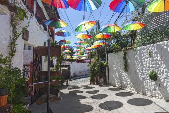 Colorful Detail with Multi Colored Umbrellas over Old Cobblestone Residential Street in Central American Town of Suchitoto, El Salvador