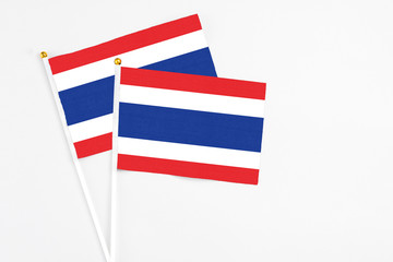 Thailand and Thailand stick flags on white background. High quality fabric, miniature national flag. Peaceful global concept.White floor for copy space.