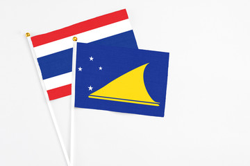 Tokelau and Thailand stick flags on white background. High quality fabric, miniature national flag. Peaceful global concept.White floor for copy space.