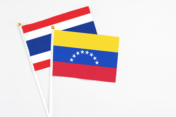 Venezuela and Thailand stick flags on white background. High quality fabric, miniature national flag. Peaceful global concept.White floor for copy space.