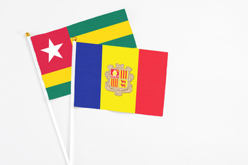 Andorra and Togo stick flags on white background. High quality fabric, miniature national flag. Peaceful global concept.White floor for copy space.