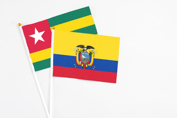Ecuador and Togo stick flags on white background. High quality fabric, miniature national flag. Peaceful global concept.White floor for copy space.