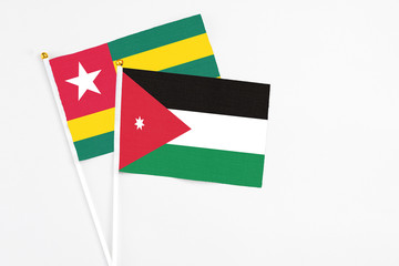 Jordan and Togo stick flags on white background. High quality fabric, miniature national flag. Peaceful global concept.White floor for copy space.