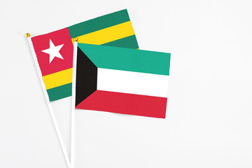 Kuwait and Togo stick flags on white background. High quality fabric, miniature national flag. Peaceful global concept.White floor for copy space.