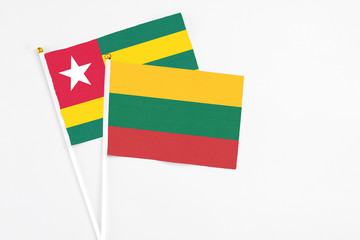 Lithuania and Togo stick flags on white background. High quality fabric, miniature national flag. Peaceful global concept.White floor for copy space.