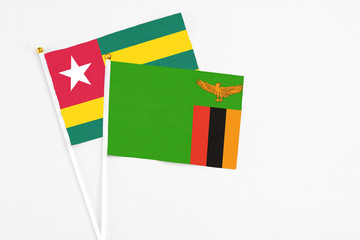 Zambia and Togo stick flags on white background. High quality fabric, miniature national flag. Peaceful global concept.White floor for copy space.