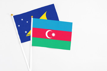 Azerbaijan and Tokelau stick flags on white background. High quality fabric, miniature national flag. Peaceful global concept.White floor for copy space.