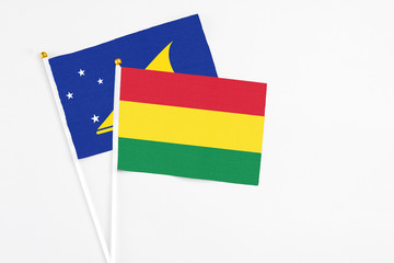 Bolivia and Tokelau stick flags on white background. High quality fabric, miniature national flag. Peaceful global concept.White floor for copy space.