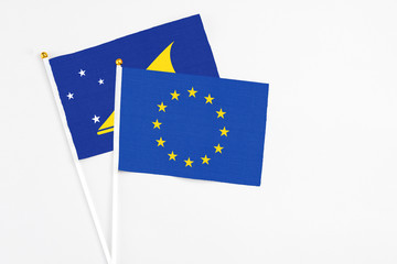 European Union and Tokelau stick flags on white background. High quality fabric, miniature national flag. Peaceful global concept.White floor for copy space.