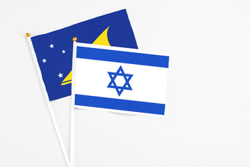 Israel and Tokelau stick flags on white background. High quality fabric, miniature national flag. Peaceful global concept.White floor for copy space.