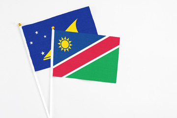 Namibia and Tokelau stick flags on white background. High quality fabric, miniature national flag. Peaceful global concept.White floor for copy space.