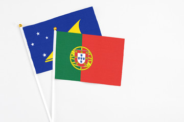 Portugal and Tokelau stick flags on white background. High quality fabric, miniature national flag. Peaceful global concept.White floor for copy space.