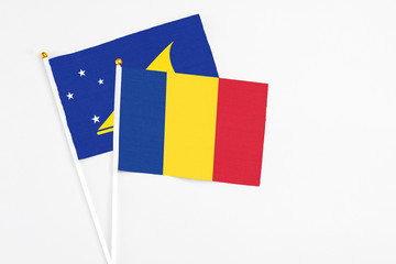 Romania and Tokelau stick flags on white background. High quality fabric, miniature national flag. Peaceful global concept.White floor for copy space.