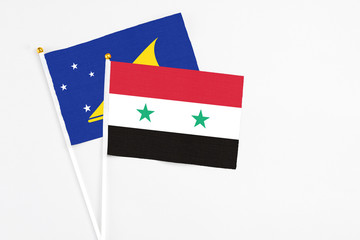 Syria and Tokelau stick flags on white background. High quality fabric, miniature national flag. Peaceful global concept.White floor for copy space.