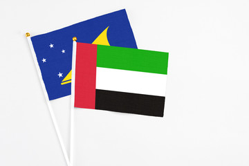 United Arab Emirates and Tokelau stick flags on white background. High quality fabric, miniature national flag. Peaceful global concept.White floor for copy space.