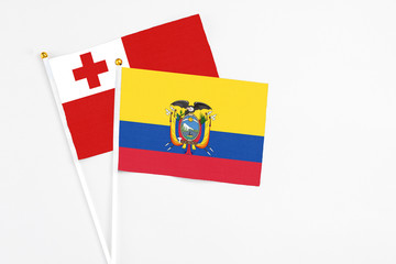 Ecuador and Tonga stick flags on white background. High quality fabric, miniature national flag. Peaceful global concept.White floor for copy space.