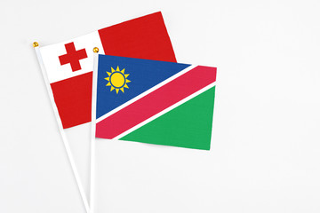 Namibia and Tonga stick flags on white background. High quality fabric, miniature national flag. Peaceful global concept.White floor for copy space.