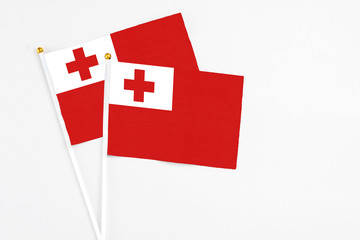 Obraz premium Tonga and Tonga stick flags on white background. High quality fabric, miniature national flag. Peaceful global concept.White floor for copy space.