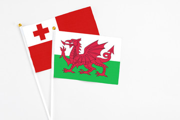 Wales and Tonga stick flags on white background. High quality fabric, miniature national flag. Peaceful global concept.White floor for copy space.