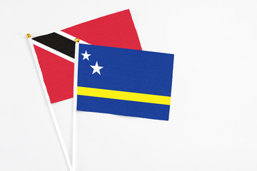Curacao and Trinidad And Tobago stick flags on white background. High quality fabric, miniature national flag. Peaceful global concept.White floor for copy space.