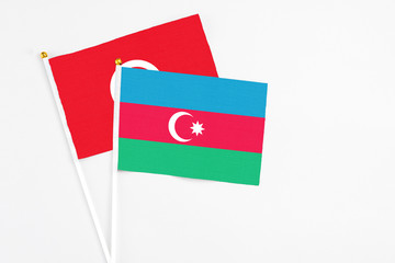 Azerbaijan and Tunisia stick flags on white background. High quality fabric, miniature national flag. Peaceful global concept.White floor for copy space.