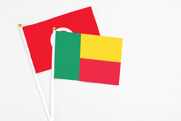 Benin and Tunisia stick flags on white background. High quality fabric, miniature national flag. Peaceful global concept.White floor for copy space.