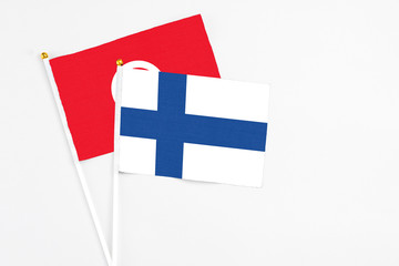 Finland and Tunisia stick flags on white background. High quality fabric, miniature national flag. Peaceful global concept.White floor for copy space.