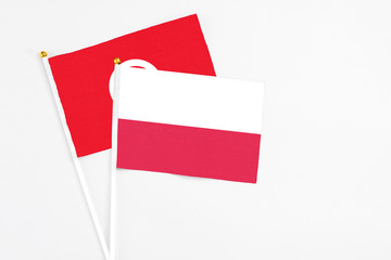 Poland and Tunisia stick flags on white background. High quality fabric, miniature national flag. Peaceful global concept.White floor for copy space.