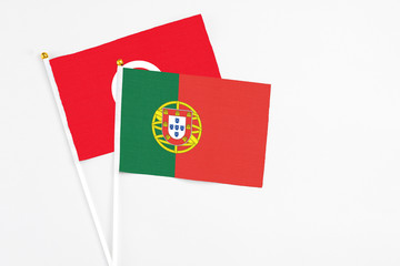 Portugal and Tunisia stick flags on white background. High quality fabric, miniature national flag. Peaceful global concept.White floor for copy space.