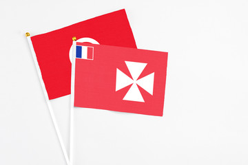Wallis And Futuna and Tunisia stick flags on white background. High quality fabric, miniature national flag. Peaceful global concept.White floor for copy space.