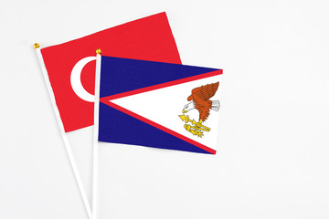 American Samoa and Turkey stick flags on white background. High quality fabric, miniature national flag. Peaceful global concept.White floor for copy space.