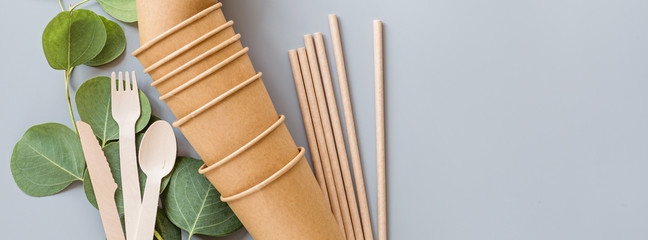 eco natural paper cups, straws, wooden cutlery flat lay on gray background. sustainable lifestyle...