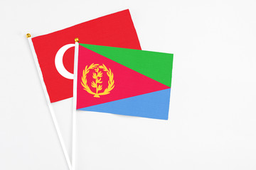 Eritrea and Turkey stick flags on white background. High quality fabric, miniature national flag. Peaceful global concept.White floor for copy space.