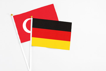 Germany and Turkey stick flags on white background. High quality fabric, miniature national flag. Peaceful global concept.White floor for copy space.