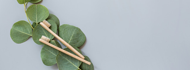 eco natural bamboo toothbrushes flat lay on gray background. sustainable lifestyle concept. zero waste, plastic free items. stop plastic pollution. Top view, overhead, template, Mockup.